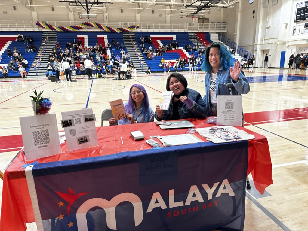 3 malaya members Kat, Justher, and Noemi posing at the Malaya Table